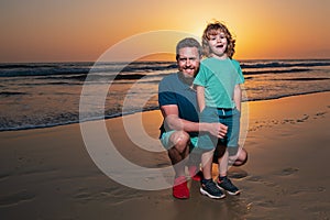 Father and son hugging on beach sunset. Dad and his little boy are together on the sea.
