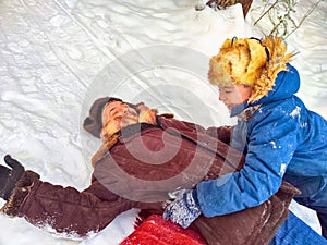 Father and son hugging, having fun, walking in snow nature. Photo shoot in stylized clothes of the USSR. Hat with