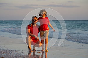 Father and son hugging in sea beach. Concept of friendly family. Happy family on beach, summer holiday vacation. Dad
