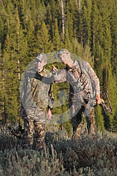 Father and son hunting together in woods