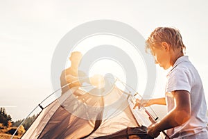 Father and son install touristic tent for camping