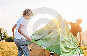 Father and son install touristic tent for camping
