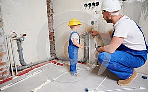 Father and son installing heating pipe system at home.