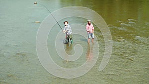 Father and son ishing. Brown trout fish. Father and son relaxing together. Generations men. Man fishing. Men fishing in