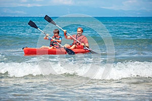 Father and son kayaking in ocean. Active vacation with young kid. Holiday activity with schoolboy child