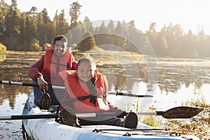 Father and son kayaking on rural lake, close up