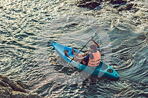 Father and son kayaking at tropical ocean.