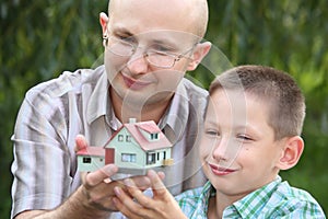 Father and son keeping in their hands wendy house