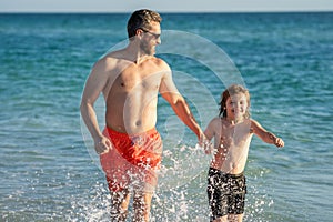 Father son kid bonding relationship. daddy and son running in sea beach. Father son child bonding enjoying summer