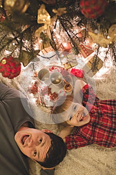 Father and son laying under christmas tree.