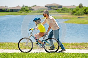 Father and son learning to ride a bicycle having fun together at Fathers day. Father teaching his son cycling on bike in