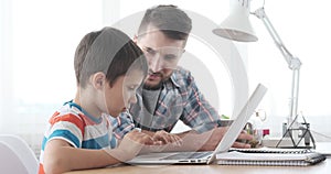 Father with son learning to use laptop