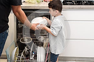 Father and son loading dishwasher together.