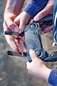 Father and son looking at remote control joystick and piloting quadrocopter