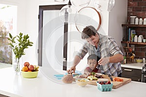 Father And Son Making School Lunch In Kitchen At Home