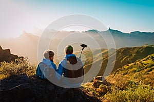 Father with son making selfie in mountains, family travel in nature