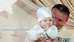 Father and son, a parent and baby play in the home in the winter, a happy family, a good dad keeps a small child in his