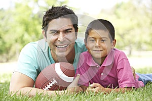 Father And Son In Park With American Football