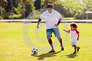 Father and son play football. Young active family
