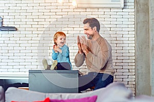 Father and son play fun together indoors.