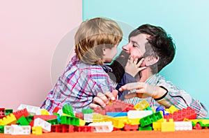 Father and son play game. building home with colorful constructor. small boy with dad playing together. child