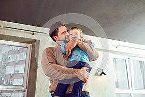 Father and son play hugs in the room.