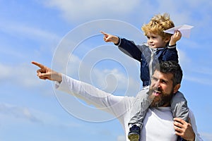 Father and son play with toy plane on the nature. Happy man family. Child playing with paper airplane. Generation