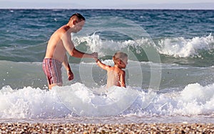 Father and son play in water