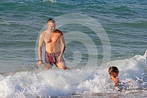 Father and son play in water