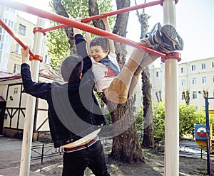 Father with son on playground training, happy family smiling outside, lifestyle people concept