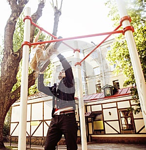 Father with son on playground training, happy real family smiling outside, lifestyle people concept