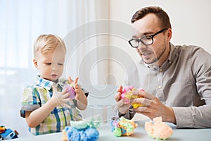 Father and son playing with ball clay at home