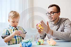 Father and son playing with ball clay at home