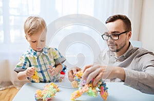 Father and son playing with ball clay at home