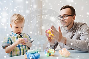 Father and son playing with ball clay at home