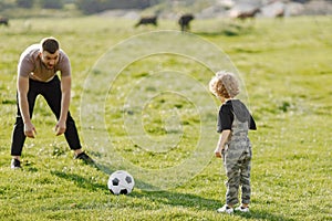 Father and son playing with a ball on summer outdoors