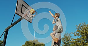 Father and son playing basketball.