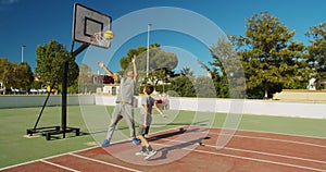 Father with son playing basketball on outdoor court.