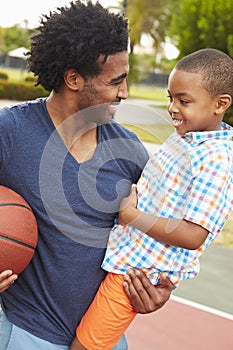 Father With Son Playing Basketball In Park Together