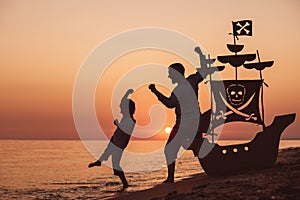 Father and son playing on the beach at the sunset time.