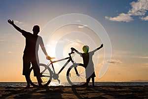 Father and son playing on the beach at the sunset time.