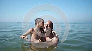 Father and son playing at beach together portrait fun happy lifestyle
