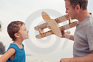 Father and son playing with cardboard toy airplane