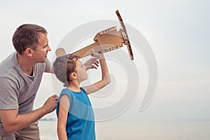 Father and son playing with cardboard toy airplane