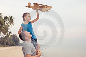 Father and son playing with cardboard toy airplane