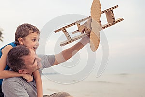 Father and son playing with cardboard toy airplane