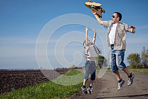Father and son playing with cardboard toy airplane in the park a