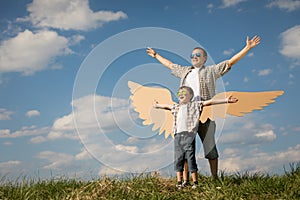 Father and son playing with cardboard toy wings