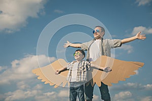 Father and son playing with cardboard toy wings