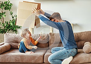 Father and son playing with carton box